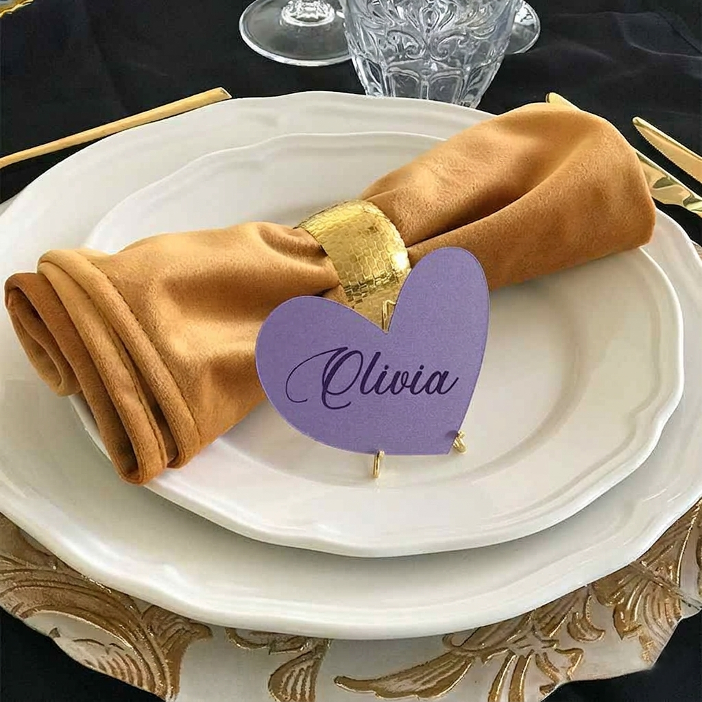Napkin folded on a plate with a purple heart-shaped name tag labeled 'Olivia' on a decorative table setting.