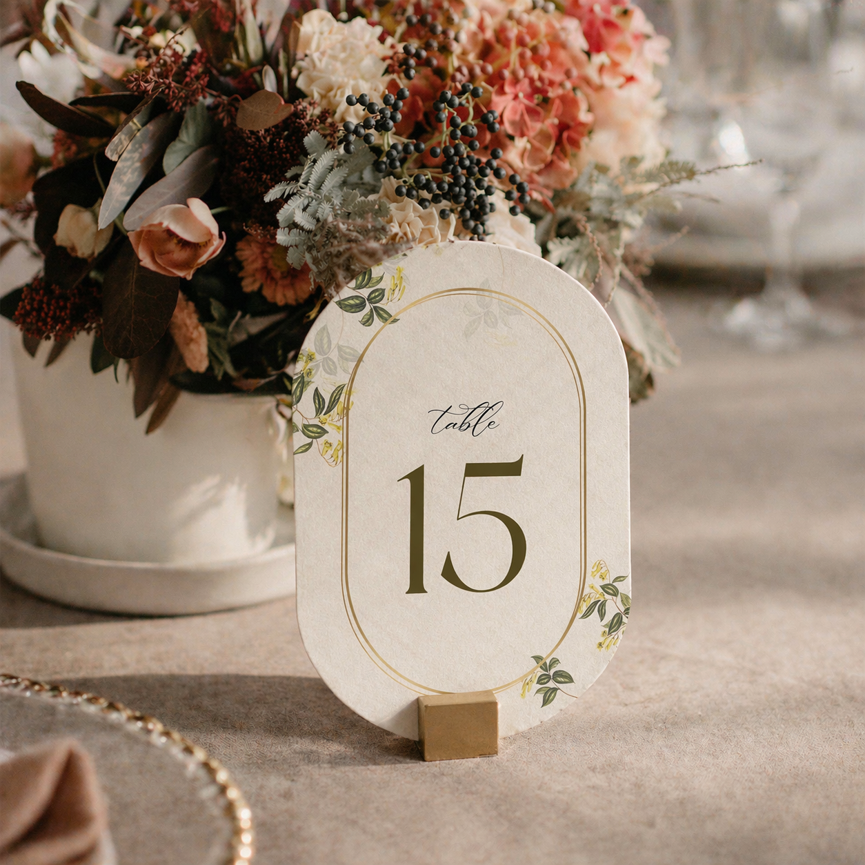 Table number 15 on a decorative stand with a floral arrangement in the background.