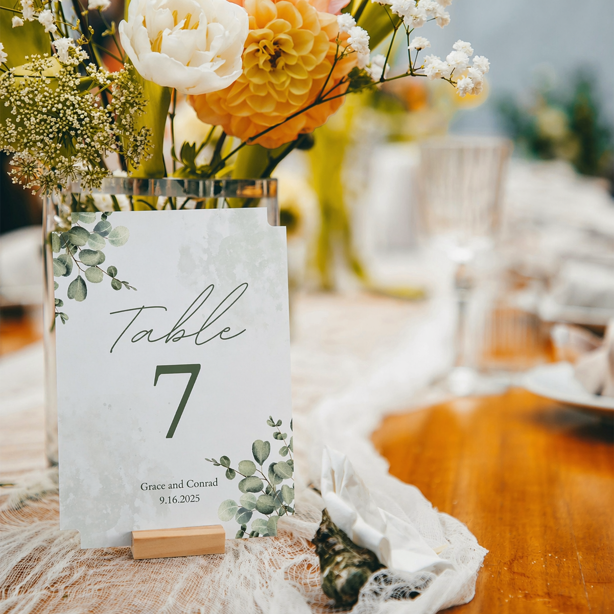 Table number card with floral arrangement on a wooden table