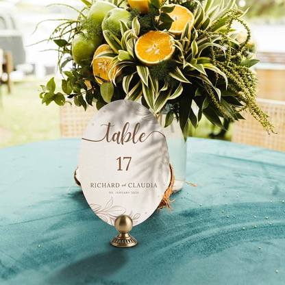 Table number card with decorative vase on a tablecloth with floral arrangement