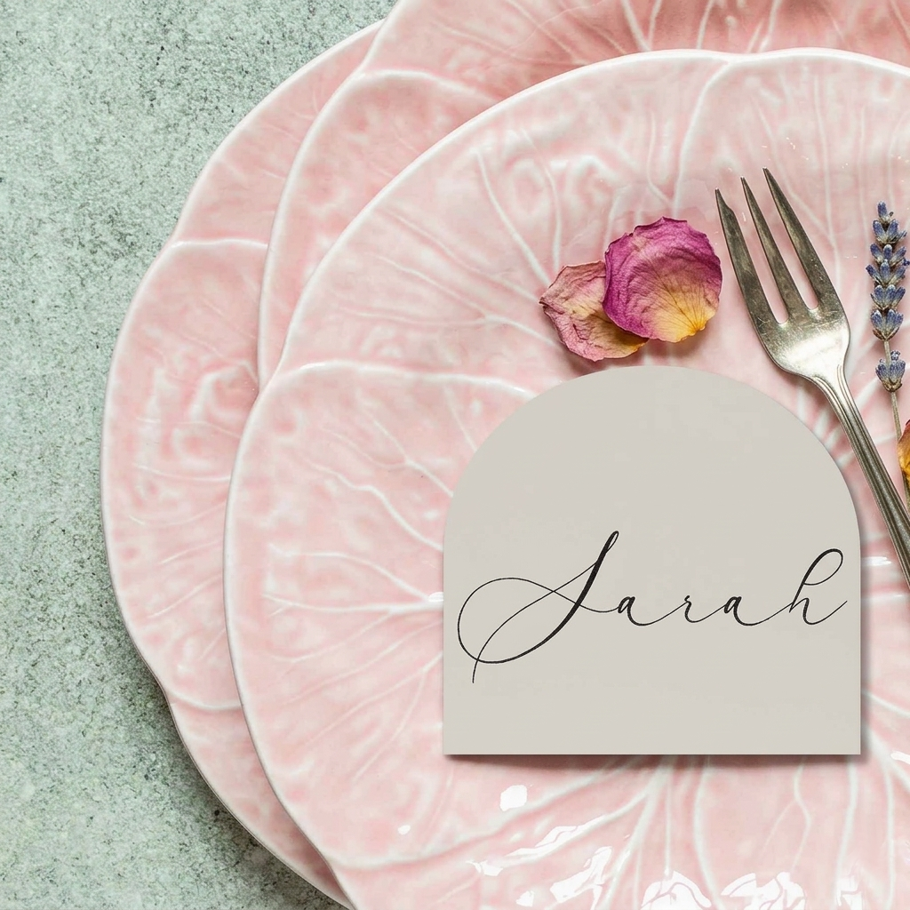 Pink marble plates with a name card labeled 'Sarah' and a fork on a light green background