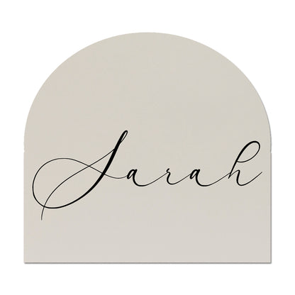 Arch-shaped wedding place card with 'Sarah' written in cursive on a white background
