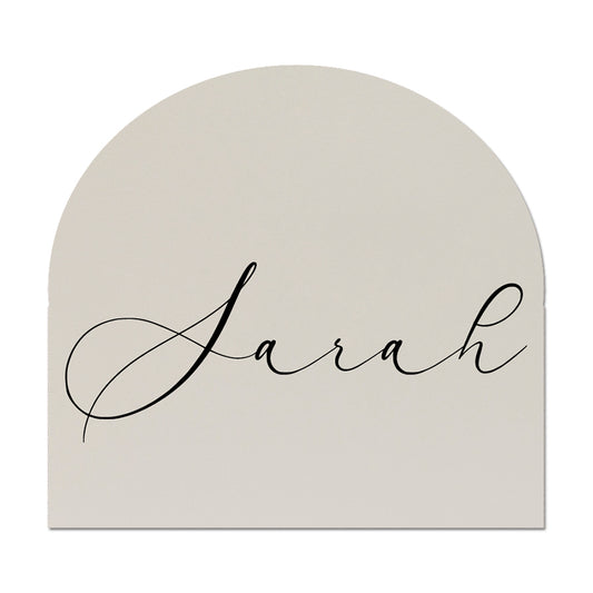 Arch-shaped wedding place card with 'Sarah' written in cursive on a white background