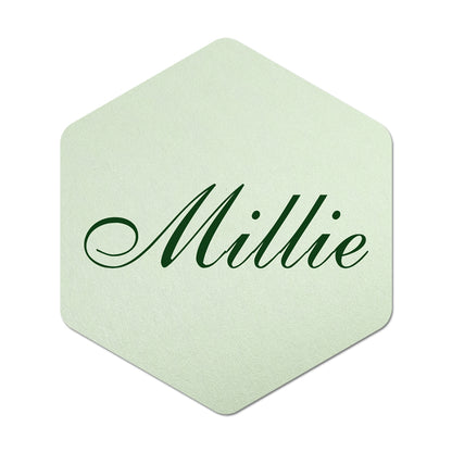 Hexagonal light green place card with 'Millie' in green text on a white background