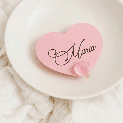 Pink heart-shaped wedding name card with 'Maria' on a white plate