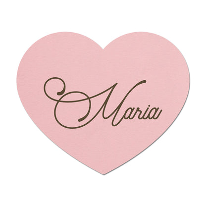 Pink heart-shaped place card with 'Maria' written on it against a white background