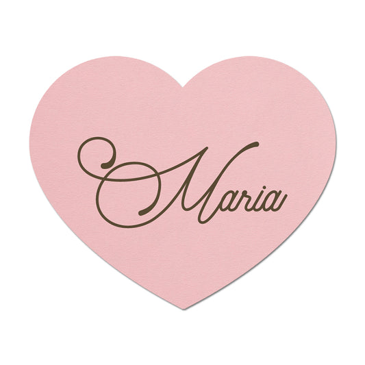 Pink heart-shaped place card with 'Maria' written on it against a white background