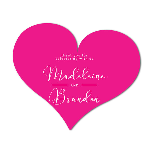 Pink heart-shaped favor card with white text for Madeleine and Brandon