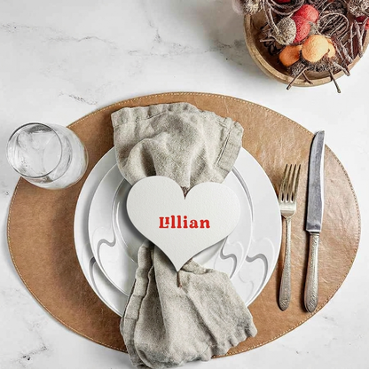 Dining table setting with a heart-shaped name card on a white plate.