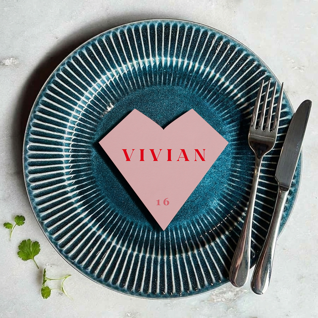 Teal plate with pink heart-shaped name card and 'VIVIAN' text on a light gray background